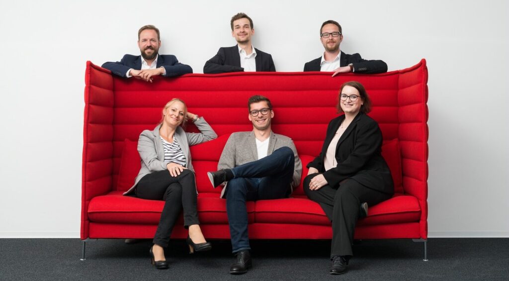 Das Meisterplanteam auf dem roten Sofa